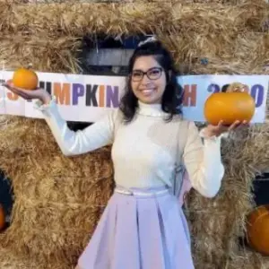 Graciela Sandov holding a pumpkin in each hand